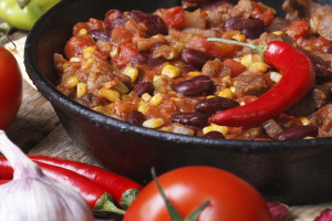 Mexican chili con carne in a pan on a wooden background